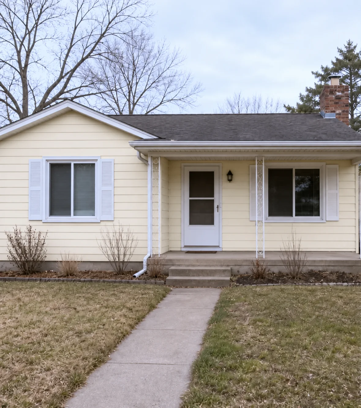 The house with warm cream siding and white window and porch trim