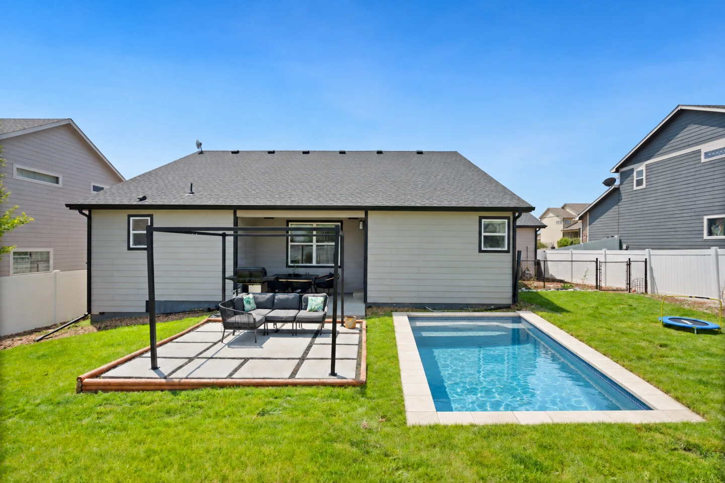 AI concept of a compact rectangular swimming pool beside the existing backyard patio