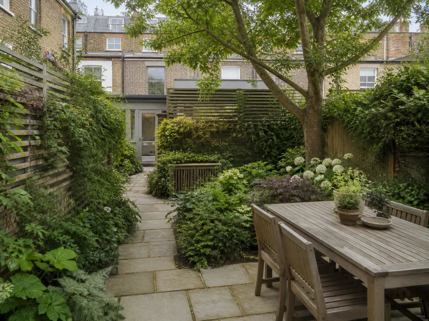 Compact city garden with layered planting and an outdoor dining area