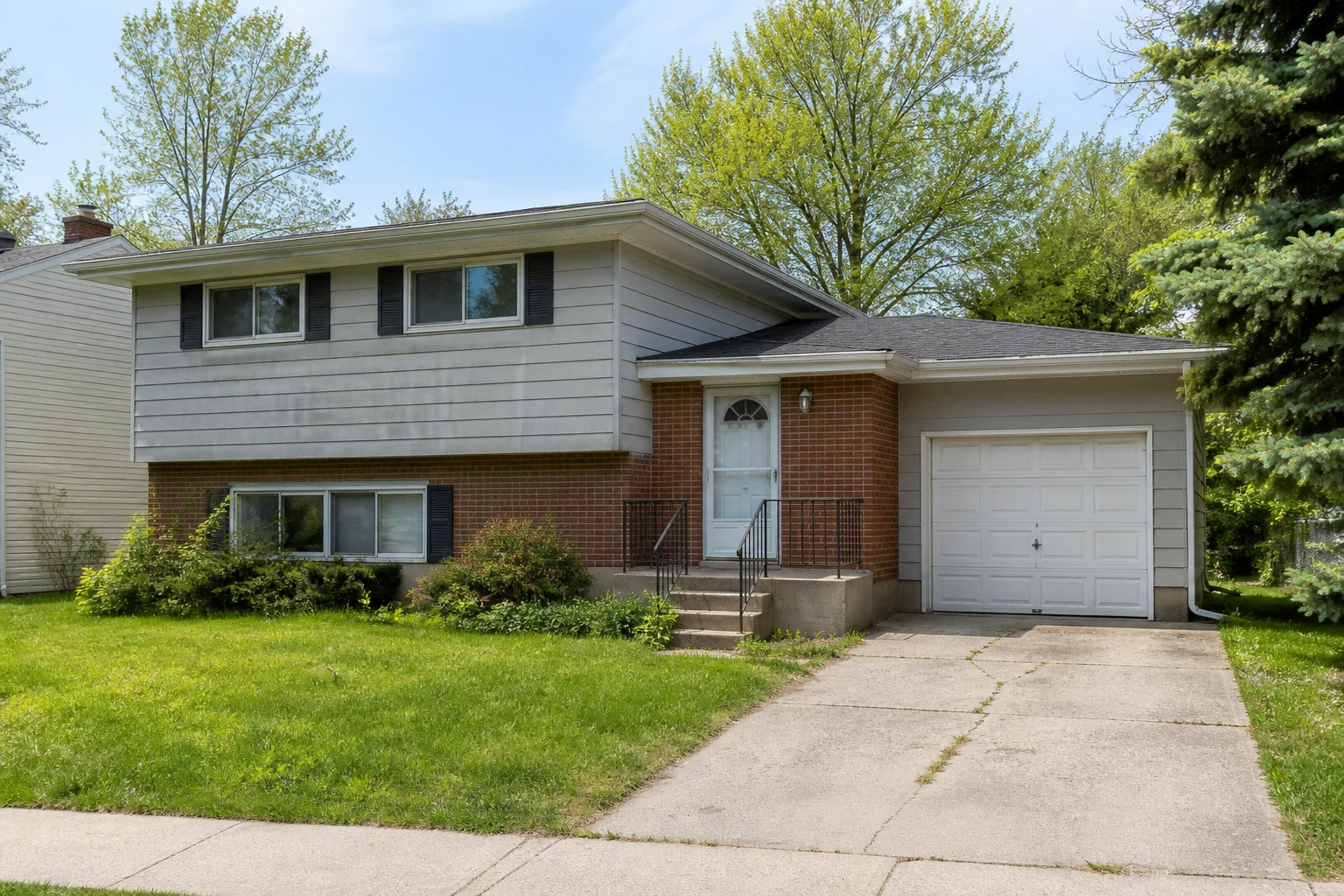 1970s brick and gray siding split-level house before an AI exterior remodel