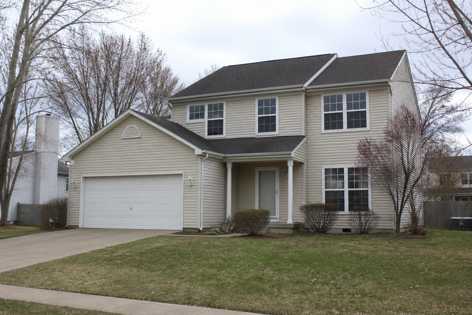 Dated beige two-story suburban house before an AI exterior design makeover