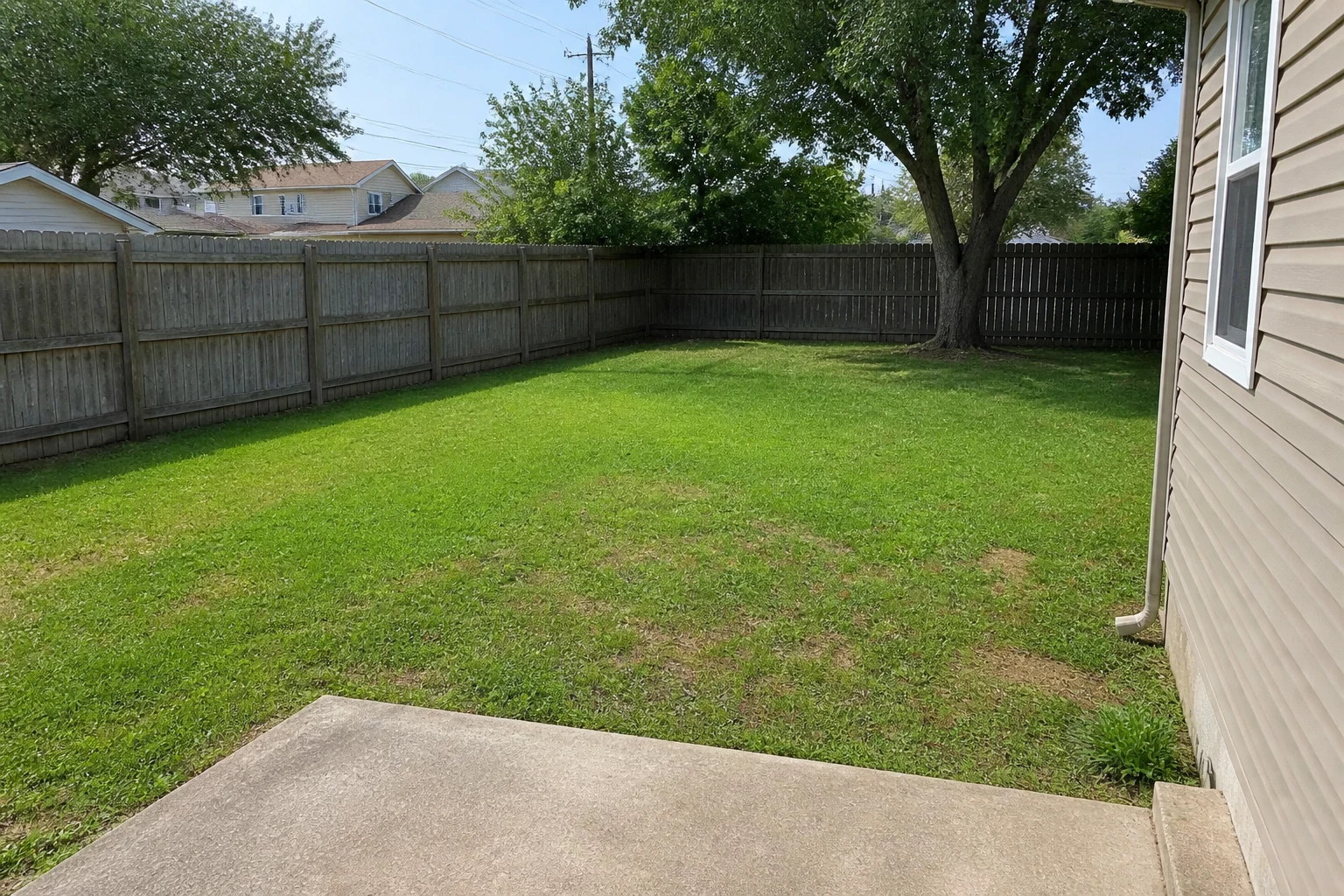 Plain suburban backyard with patchy lawn before AI landscape design