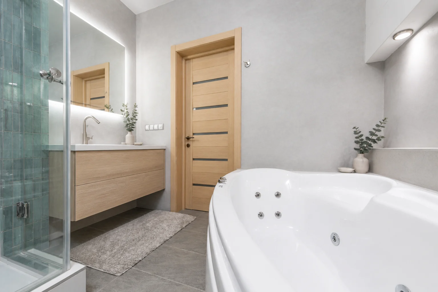 Real compact bathroom redesigned with gray plaster and blue-green tile
